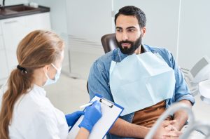 dentist talking to patient in dental chair